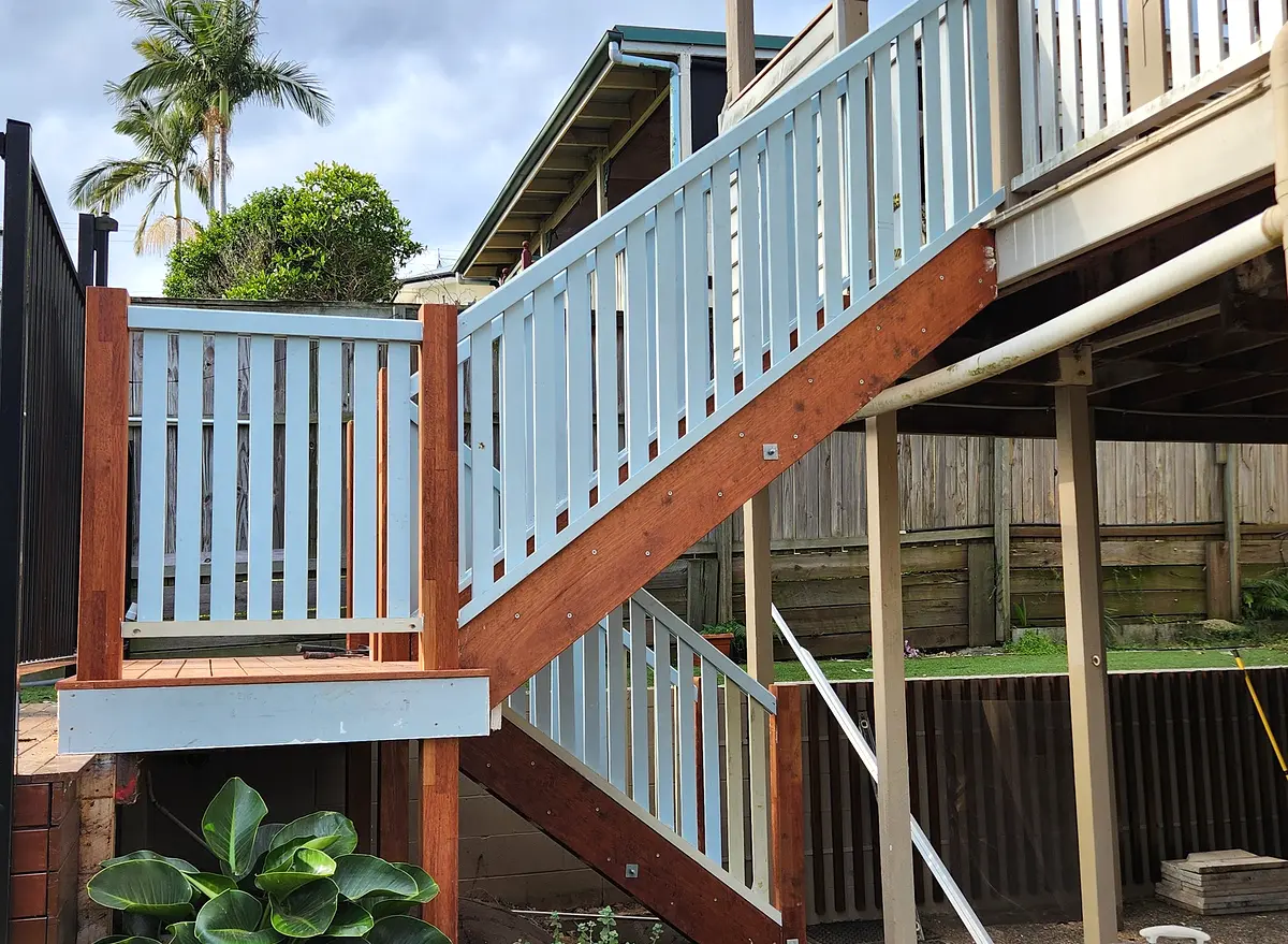 Completed double-flight hardwood staircase with white balustrades